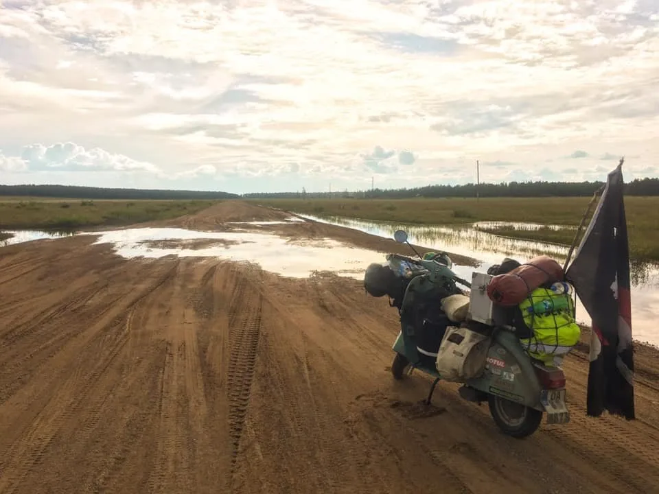 Vespa on flooded sand road in Siberia during 80 day world circumnavigation 2018