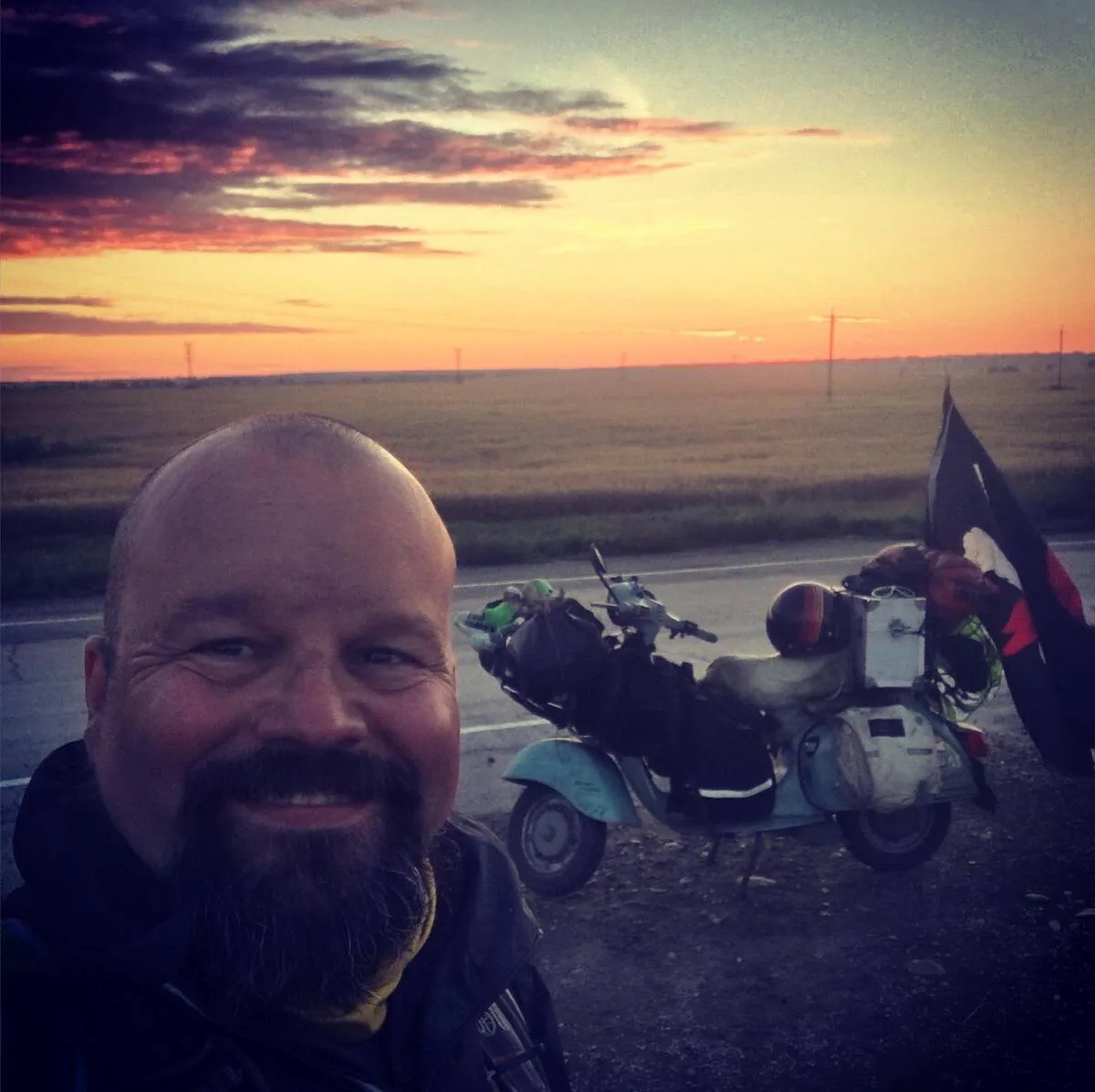 Markus André Mayer selfie with loaded Vespa at sunset on the Russian steppe during 80 day world circumnavigation 2018