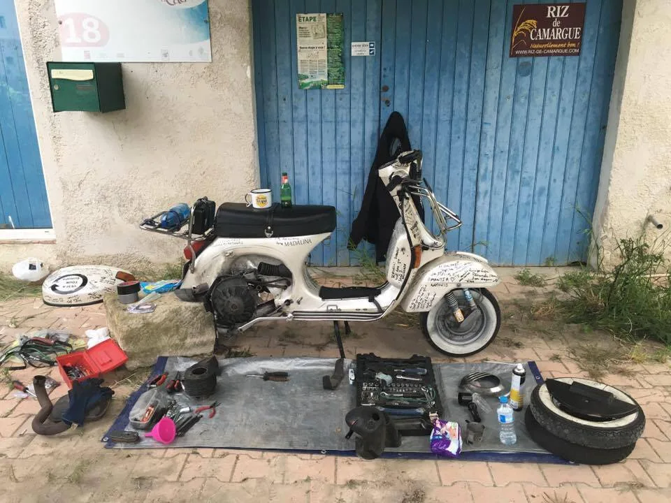Madalina Vespa P200E completely stripped down for engine repair on gravel car park Camargue France 2016