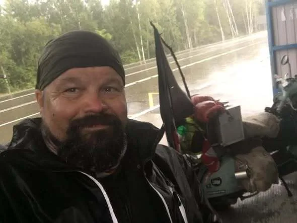 Markus André Mayer sheltering in a bus stop in Siberia during heavy rain — Vespa world circumnavigation 2018, day 52