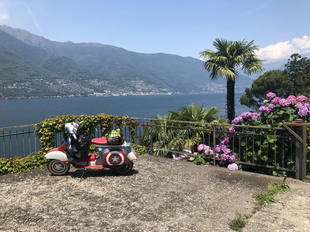 Cap10 Vespa parked at Lago Maggiore Italy with palm trees and mountains 2023