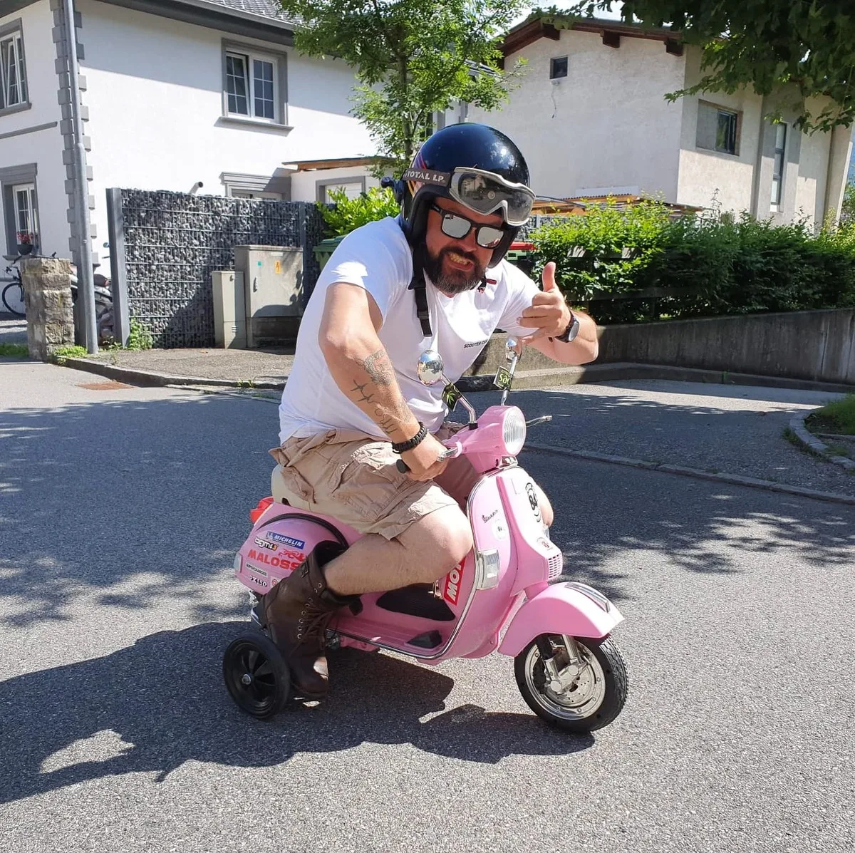 Markus André Mayer on a pink childrens Vespa with training wheels — not special, just having fun