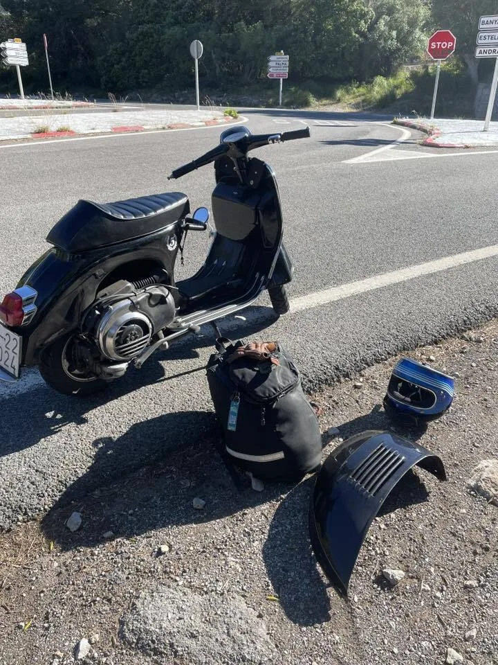 Valentina 1967 Vespa GS150 with side panel removed for spark plug change on Mallorca roadside — Vuelta Balearica 2026