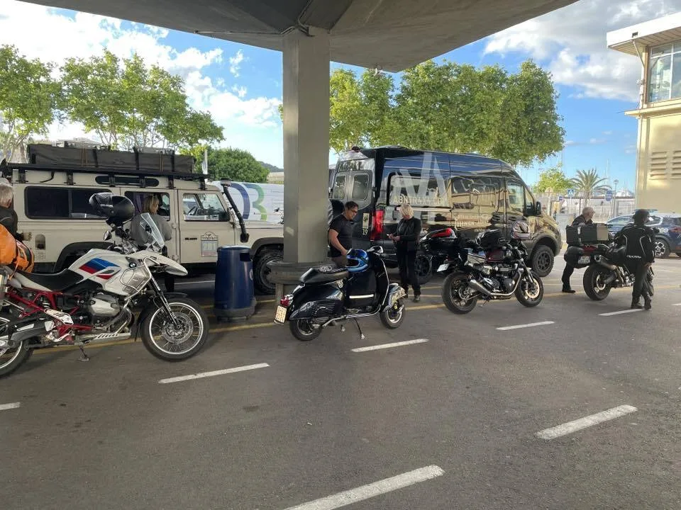 Valentina 1967 Vespa GS150 at Palma ferry terminal surrounded by BMW GS motorcycles and Land Rovers — the only Vespa on the ferry Vuelta Balearica 2026