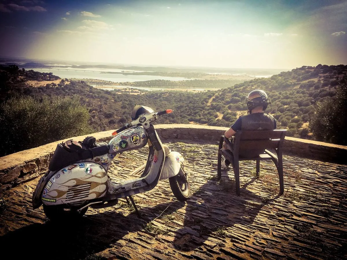 Markus André Mayer resting with his Vespa overlooking the Alentejo landscape Portugal — Penistour 2023