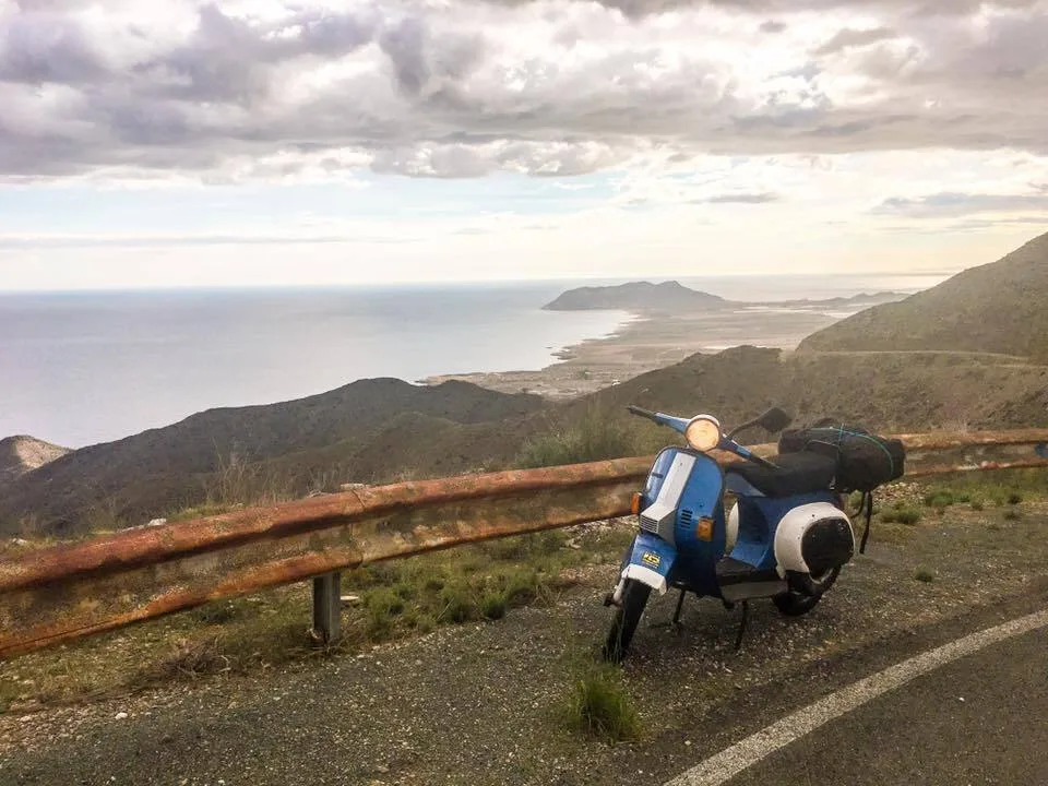 Blue Vespa PK50 on Spanish coastal road — 50cc Iberian Micro-Adventure 2018