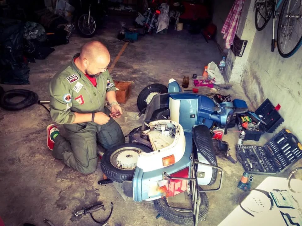 Markus André Mayer repairing Vespa PK50 in garage Cartagena Spain 2018 — Malditos Domingos Scooterclub