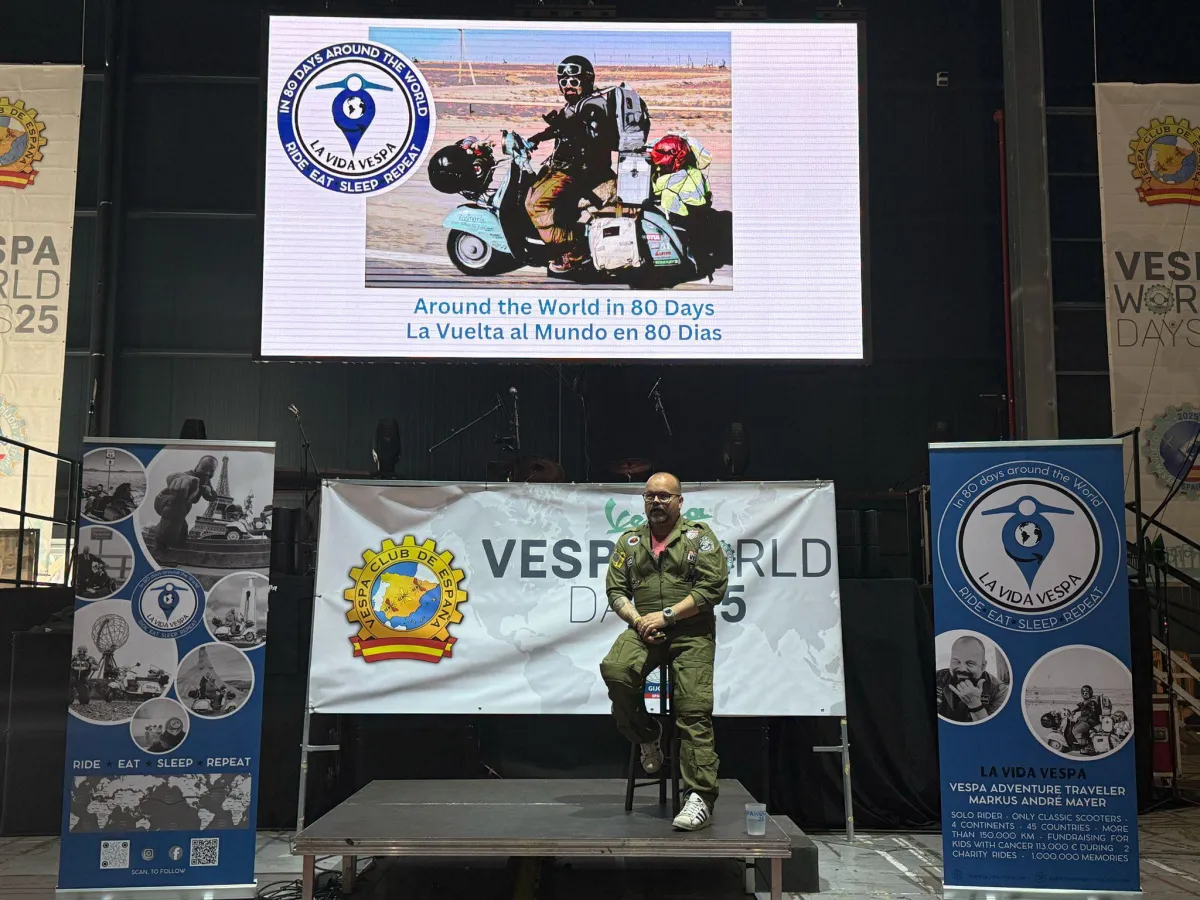 Markus André Mayer speaking on stage at Vespa World Days Gijon — vespa adventure travel keynote speaker