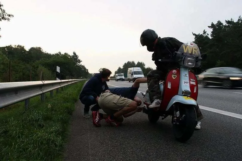 Support team inspecting Scomadi TL125 on emergency lane after exhaust failure, Germany 2015